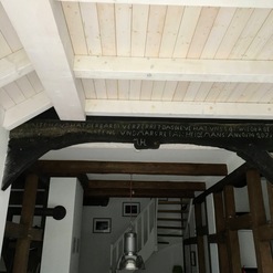 Moderne und traditionelle Elemente kombiniert in einem Fachwerkhaus mit sichtbaren Holzbalken und weißer Holzdecke.