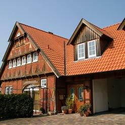 Ein charmantes Fachwerkhaus mit detaillierter Arbeit einer Zimmerei, sichtbaren Holzstreben und einem leuchtend roten Ziegeldach.