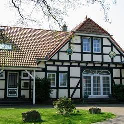 Sorgfältig restauriertes Fachwerkhaus mit weiß-schwarzer Fassade und Ziegeldach, Zeugnis der meisterhaften Arbeit einer Zimmerei.