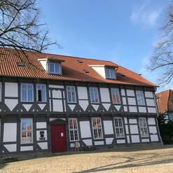 Ein großes Fachwerkhaus mit mehreren Fenstern und einem Ziegeldach, zeigt die historische Arbeit einer Zimmerei.