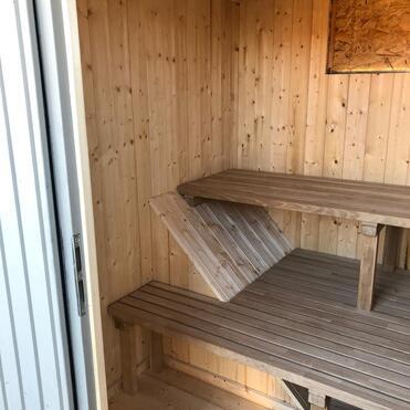 Holzvertäfelte Sauna mit eingebauten Bänken, ein Beispiel für qualitativ hochwertigen Saunabau mit natürlichen Materialien.