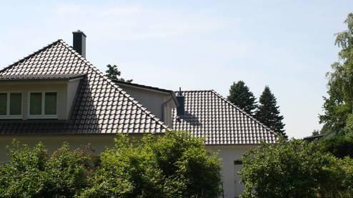 Blick auf ein großes Haus mit schwarzen Dachziegeln